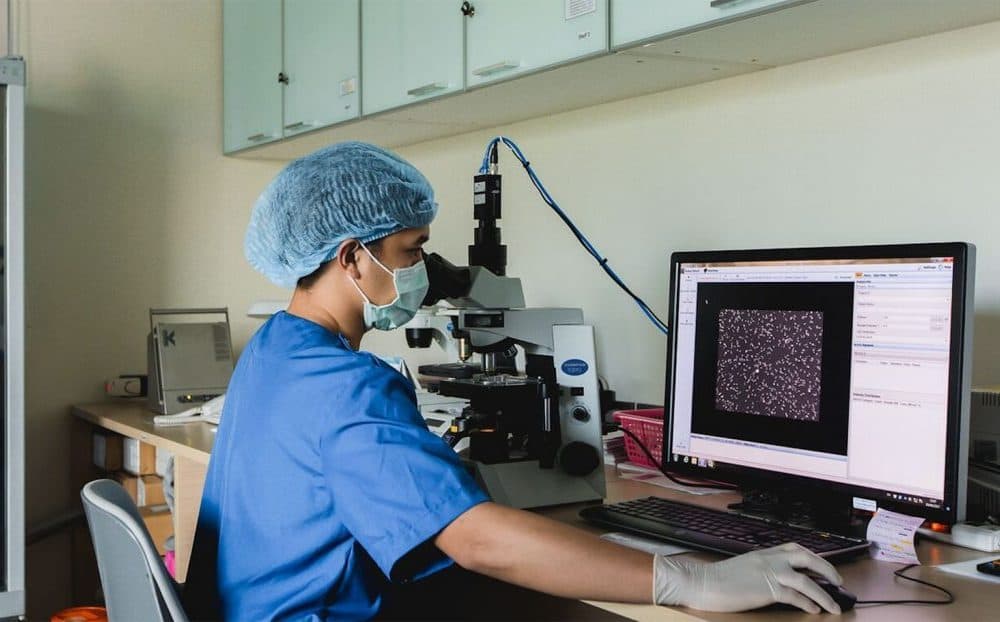 นักวิทยาศาสตร์ตัวอ่อนทำงานที่กล้องจุลทรรศน์และจอภาพในห้องปฏิบัติการ IVF